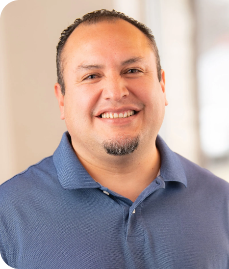 headshot of employee wearing a corn blue collared shirt