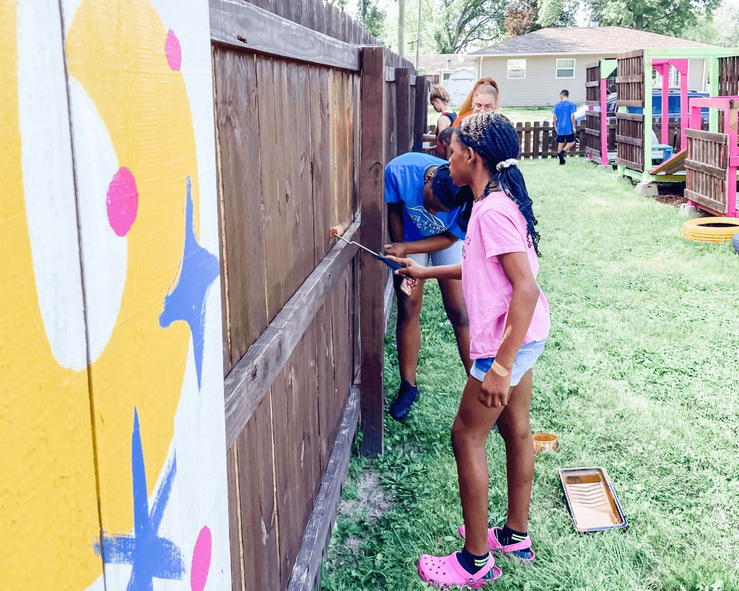 kids painting a fence featured on the neighborhood revitalization landing page